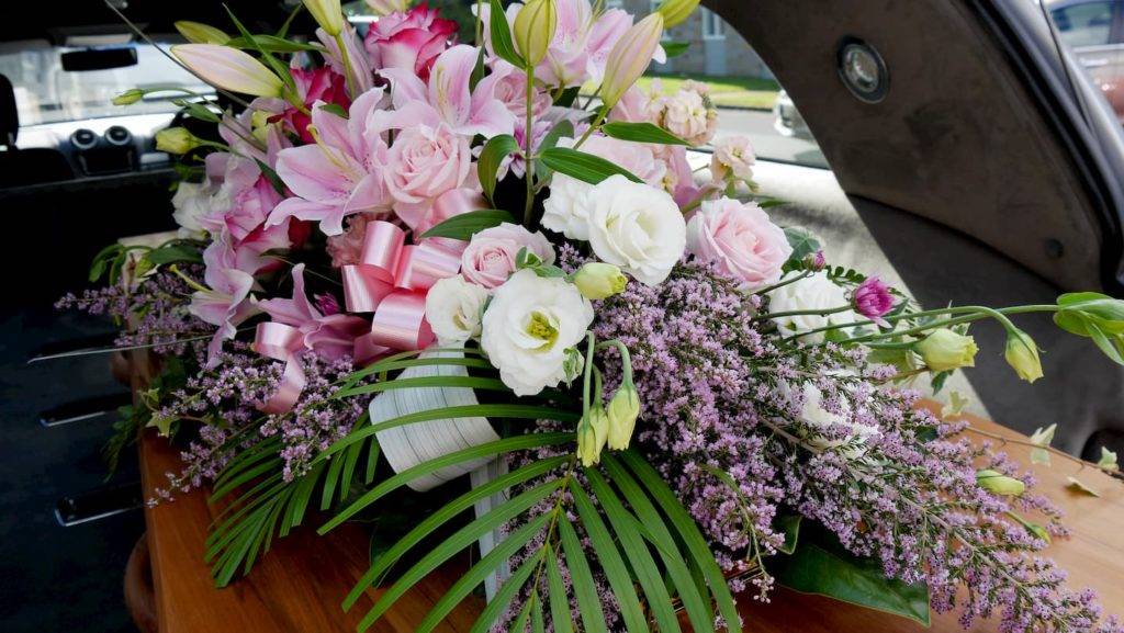 Funeral flowers on top of coffin