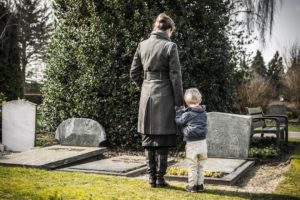 mother and child stood at a grave